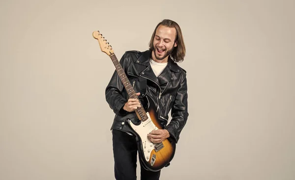 man long hair play electric guitar. rock music style. musician guitar player. masterfully playing rock music. stylish crazy man. string musical instrument. happy bearded rocker in leather jacket.