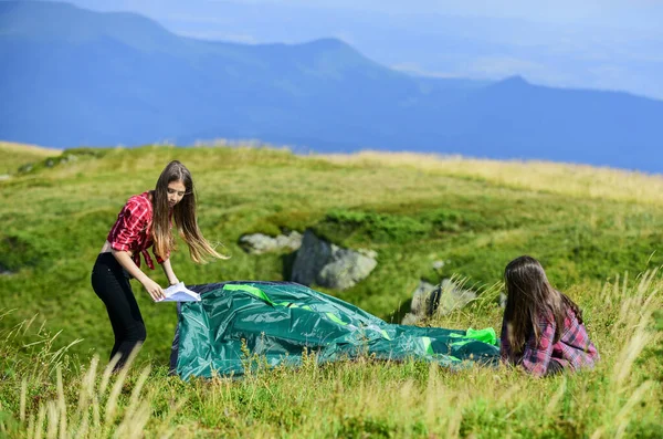 Kamp ve yürüyüş. Yaz maceraları. Geçici konutlar. Kamp gezisi. Çadır kuracak bir ortağın olması ne güzel. Kamp becerileri konsepti. Hiçliğin ortasında. Kızlar dağın tepesine çadır kurar..