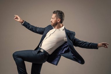 Elinden gelenin en iyisini yapıyorsun. Kişisel başarı hedefi. Gri arka planda dans eden adam. Kendine güvenen iş adamı resmi takım elbise giyer. Şirket partisini kutlayalım. Ofis hayatından zevk alıyorum. İş başarısı. mutluluk.