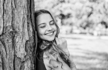 Mutlu kız bebek gülüşü ile güzellik, kapalı gözler güneşli yaz manzarasında ağaç gövdesi, mutluluk.