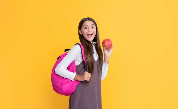 Überraschte Kind Mit Schulrucksack Und Apfel Auf Gelbem Hintergrund — Stockfoto