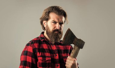 Keşif araçları. Erkek modası. Baltalı yakışıklı hippi. Oduncu ya da baltalı adam konsepti. Kareli gömlekli vahşi sakallı bir oduncu. Baltalı olgun bir adam odun kesiyor..