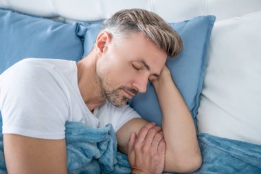 Olgun adam yatakta rahatla. Sabah erken saatlerde.