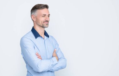 Neşeli olgun CEO gri arka planda iş gömleği giyer..