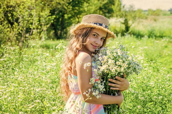 幸せな小さな子供は長い波状の髪に太陽の帽子を着用する美しいカモミールの花のスパと夏の風景の美しさのケアを保持し 見てください — ストック写真