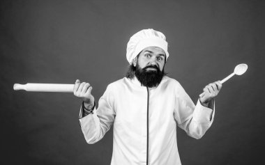 Oda servisi konsepti. Olgun sakallı adam şef şapkası takar. Erkek aşçı yemek hazırlamaya hazır. Önlüklü vahşi hippi yemek pişirecek. Yemek zamanı. Bununla ne yapacağımı bilmiyorum..