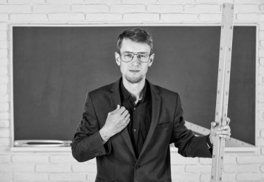 Tahtadaki adam. Okula dönüyorum. Boyutu ne? Geometri favori konusu. Erkek öğretmen matematik cetvelini tutuyor. Eğitim ve okul konsepti. Kök okul disiplini. Matematik ve insanlar kavramı.