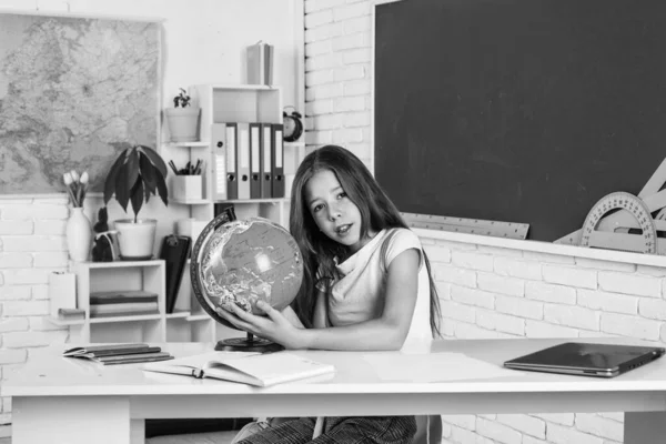 find the location. cheerful kid learning geography. modern education. knowledge day. child pupil use globe. girl is college student. back to school. teen girl work in classroom near blackboard.