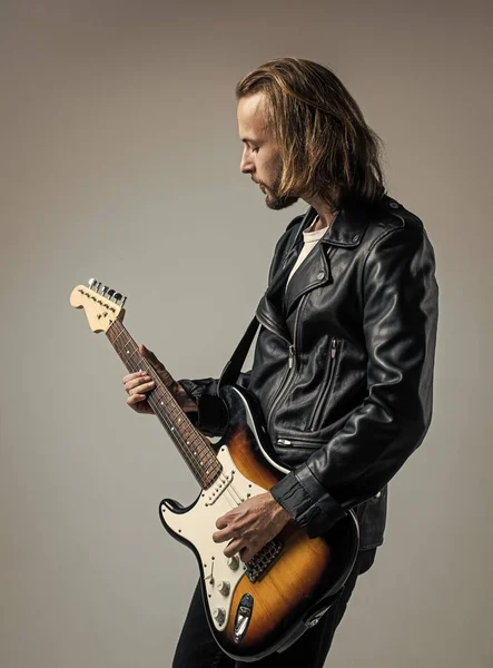 hard rock. rock music style. musician guitar player. masterfully playing music. stylish crazy man. string musical instrument. bearded rocker in leather jacket. man long hair play electric guitar.