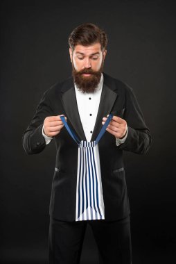 Smokinli, papyonlu, siyah fonda resmi kıyafet giyen, iş ödülü olarak alışveriş torbasında olan hayret verici bir adam. özel selamlama.