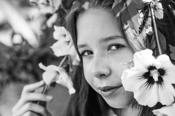 アロマ 夏のファッションと美しさ ハイビスカスの茂みの花を持つ美しい10代の女の子 子供の春ファッションスタイル 幸せな子供時代 屋外の木の開花時に明るい子供 休暇の時間 — ストック写真