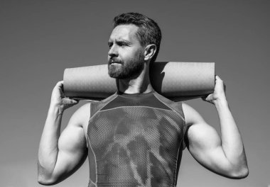 Gökyüzü arka planında yoga minderi olan pilates eğitmeni, spor.