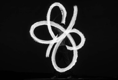 Solo ateş sanatçısı gece karanlığında gökyüzünde alevli pois döndürerek sonsuz spiraller gerçekleştiriyor..