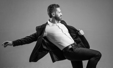 Elinden gelenin en iyisini yapıyorsun. Kişisel başarı hedefi. Gri arka planda dans eden adam. Kendine güvenen iş adamı resmi takım elbise giyer. Şirket partisini kutlayalım. Ofis hayatından zevk alıyorum. İş başarısı. mutluluk.