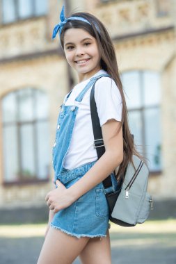 Sırt çantalı kotçu kız dışarıda poz veriyor..