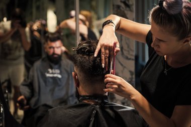 Berber dükkanındaki hippiden berber stilistine yakın plan sakal..