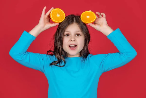 Έκπληκτος Έφηβος Παιδί Κρατώντας Πορτοκαλί Φρούτα Μωβ Φόντο — Φωτογραφία Αρχείου
