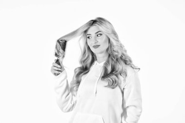 Güzel Saçların. Mükemmel makyaj ve bukleler. Güzel yüz. Kuaför salonu. Sağlıklı uzun sarı saç. Saç fırçası kullanarak uzun saçlarını kıvıran güzel bir kadın. Güzellik ve moda. Saç stili dalgalı bukleler.