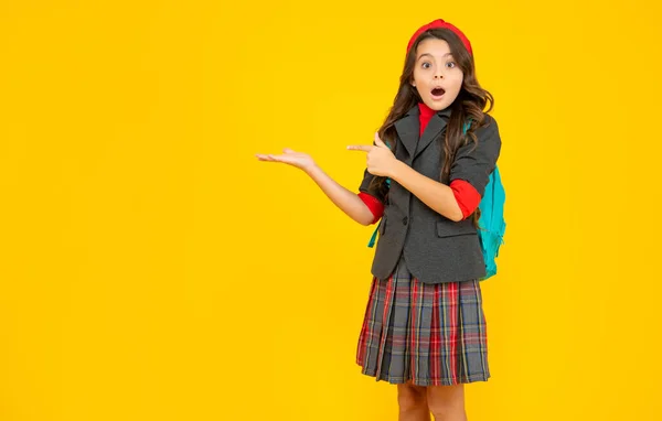 Verbaasd Kind Schooluniform Met Rugzak Wijzende Vinger Gele Achtergrond Kopieerruimte — Stockfoto