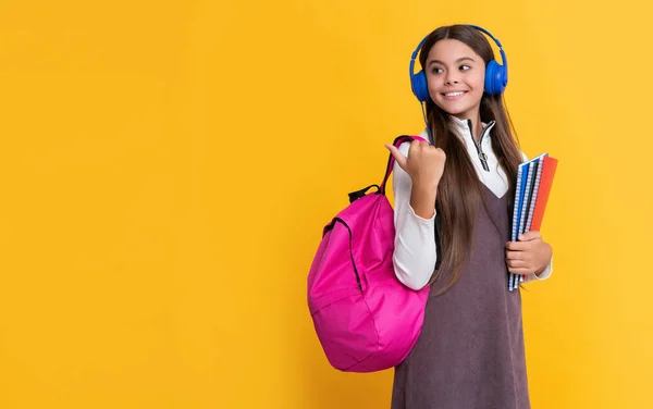 Szczęśliwa Dziewczyna Słuchawkach Szkolnym Plecakiem Skoroszytem Żółtym Tle — Zdjęcie stockowe