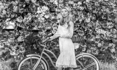 Sonsuza dek genç. giyinmiş güzel bir kadın. Klasik bisikletli kız. Çiçekli sakura ağacı. Yaz moda güzeli. Bayan parkta yürüyor. Pembe kiraz ağacı çiçeği. Kız geçmişe dönük bisikletle çiçek taşıyor..