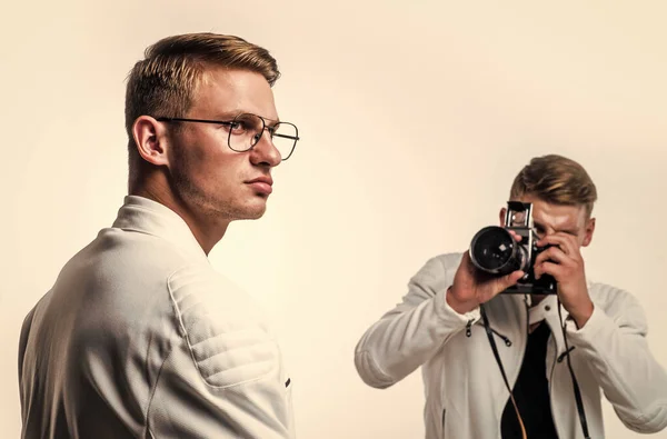 twin brothers men look alike use vintage photo camera, photographing.