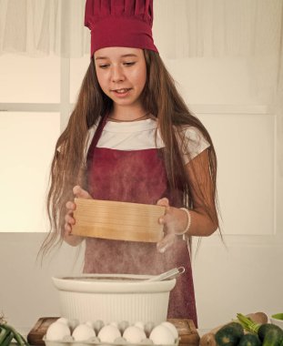 Diyet yapıyorum. Genç fırıncı çocuk mutfakta yemek hazırlıyor. Akşam yemeği için yemek pişirmek. Mutlu çocukluk gelişimi. Çocuk aşçı üniforması giyiyor. Sadece sağlıklı ürünler kullanın. Vitamin dolu. Yiyeceklerle oynamak..