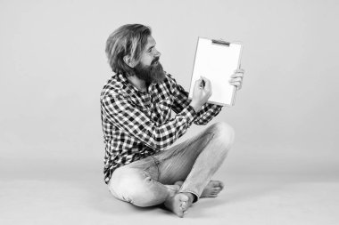 Kopyalama alanı için yer gösteriliyor. Kağıda bazı notlar yazıyorum. Hafta sonunu planlıyordu. Çok iş var. Güzel, yakışıklı bir emlakçı klasörü tutuyor ve pozitifliğini ifade ediyor. insanlar ve kurumsal konsept.