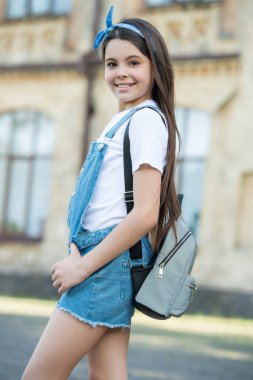 Sırt çantalı, dışarıda poz veren kotçu kız..