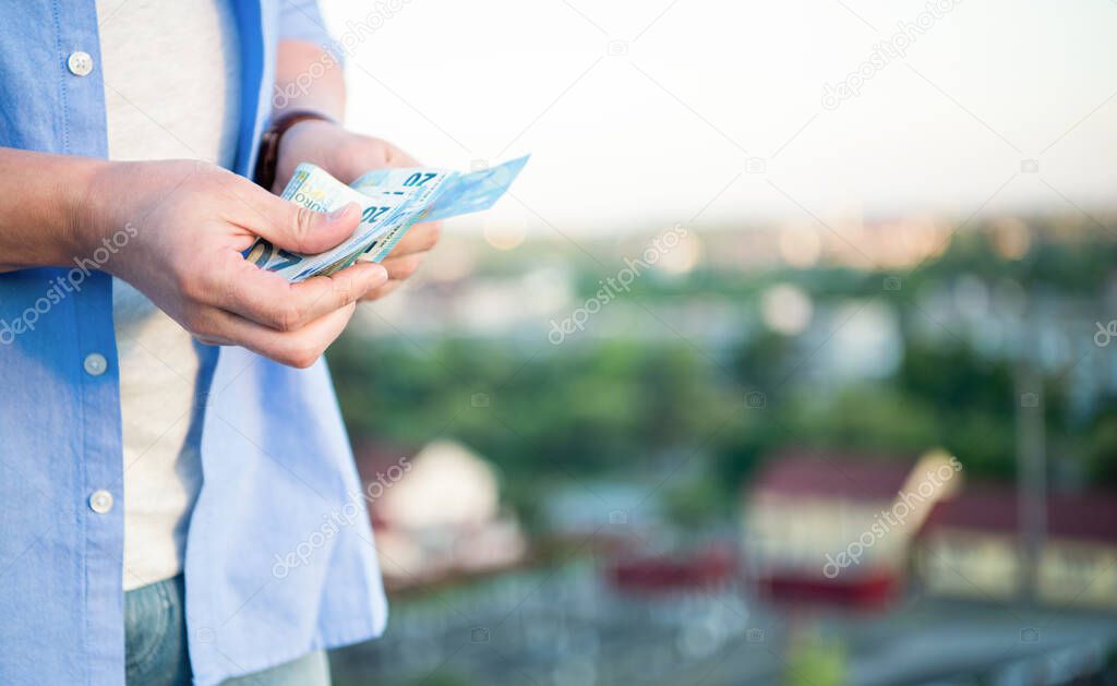 Guy crop view recounting cash money banknotes blur outdoors, copy space.