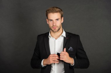 Patron gibi davran. Patron, akıllı telefonu takım elbisesinin cebinden çıkarıyor. Profesyonel bir adam. Ciddi bir yönetmen. İş adamı koyu arkaplan.