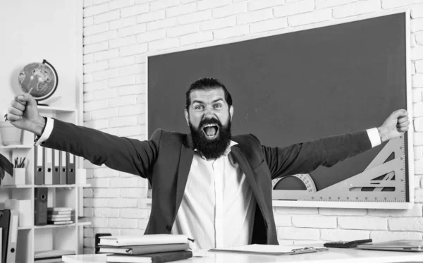 results in studying. informal education. male student sit in school classroom while lesson. pass the exam. learning the subject. shouting man with beard celebrate success.