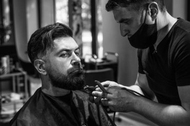 Berber dükkanında yakışıklı bir adamın saçını kesen çekici berber, kuaför aletleri..