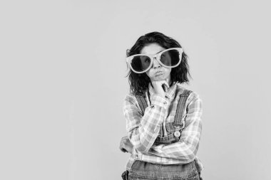 Komik suratlar yapıyor. Kopya alanı olan kız. Mutluluğu ve neşeyi hisset. Kot pantolon giymiş, parti gözlüklü güzel bir kadın. Parti zamanı. Güneş gözlüklü kadın. Neşeli kadın etkinlik yöneticisi.