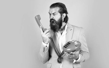 Beni duyuyor musun? Sakallı hippi retro telefon kullanıyor. İletişim konsepti. Bıyıklı vahşi yakışıklı adam telefonda konuşuyor. Ara ve konuş. modern ve klasik teknoloji.