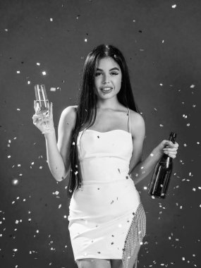 Kadın parti kutlaması. Güzel bayan doğum gününü kutluyor. Formalite içinde genç bir kız. Cazibeli kadın konfeti altında eğleniyor. Seksi kadın şampanya ve bardak iç..