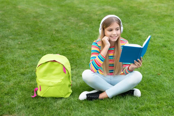 Gelukkig Tiener Meisje Lezen Boek Luisteren Naar Koptelefoon Zitten Gras — Stockfoto