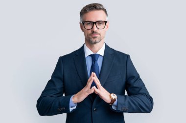 Resmi takım elbiseli kendine güvenen olgun bir adam gözlük takar..