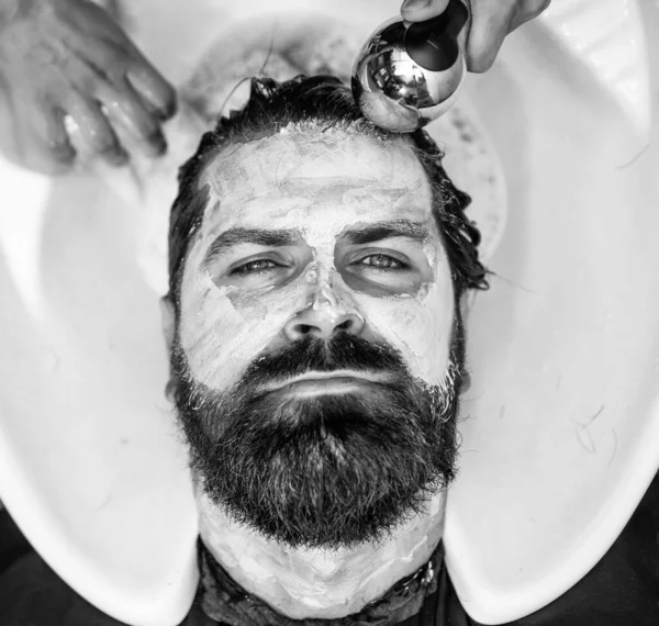 Bodycare cosmetic. barber master wash hair and face hair. mature hipster with beard at hairdresser. brutal hipster with moustache wash hair before hairstyle. barbershop washbasin. male trendy hairdo.