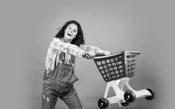 流行の服で笑顔の女性のヒップスターはショッピングカートを運ぶ サイバー月曜日 — ストック写真