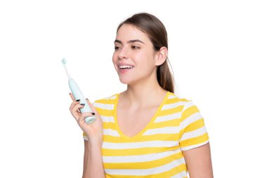 Beyaz arka planda elektrikli diş fırçası olan mutlu genç bir kız..