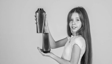 Buraya bak. Çocuk şişede şampuan kullanıyor. Saç kremi. Güzellik. Yıka ve durula. Mutlu genç kız kozmetik ürünleri sunuyor. Kuaförde saç şampuanlıyordum. Günlük alışkanlıklar ve kişisel bakım.