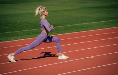 Vücuduna uygun. Kadın sporcu spor yapıyor. Antrenör ya da koç eğitimi. Mükemmel vücut şekli. sağlıklı ve sportif. Spor giyim bölümündeki seksi fitness kadını. Atletik bayan stadyumda ısınıyor..