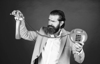 Bu da ne? Modern ve klasik teknoloji. Sakallı hippi retro telefon kullanıyor. İletişim konsepti. Bıyıklı vahşi yakışıklı adam telefonda konuşuyor. Ara ve konuş.