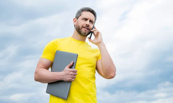 Hombre Con Ordenador Portátil Hablando Teléfono Inteligente Fondo Del Cielo — Foto de Stock