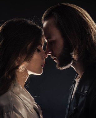 İlişkilerde sorunlar. Aşk ve romantizm. Romantik ilişki. Sevgili olarak. Öpücük. Birbirine aşık çiftler. Modaya uygun bir çift portresi. Uzun sakallı, uzun saçlı adam, kadını öpüyor..