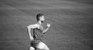 Atletik adam sprint 'te yarışıyor. Spor, sağlıklı yaşam tarzı. Spor salonu açık havada. Koşucu pistte hızlı koşar. Enerjik ve sportif. Maraton hız enerjisi. Kaslı adam hareket halinde..