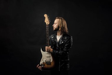 Rock müzik stili yıldızı. müzisyen gitarist. Rock müziğini ustaca çalmak. Modaya uygun çılgın adam. müzik enstrümanı. Deri ceketli sakallı rockçı. Uzun saçlı adam elektro gitar çalıyor..