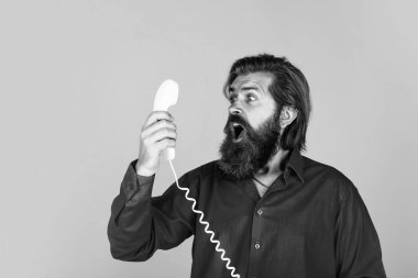 Yakışıklı, sakallı, şık saçlı, antika telefon kullanan bir adam..