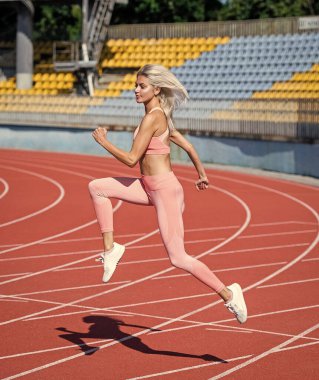 Spor salonundaki atletik kadın stadyumda koşuyor..